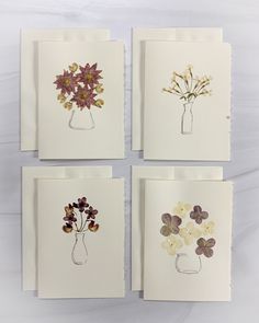 four cards with flowers in vases on them