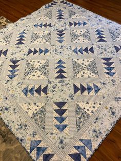 a blue and white quilt is laying on the floor