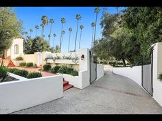 an entrance to a home with palm trees in the background