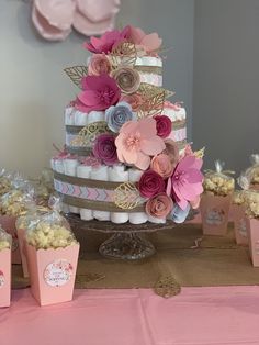 there is a wedding cake with pink flowers on the top and other decorations around it