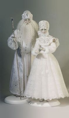 two figurines are standing next to each other wearing white clothing and holding canes