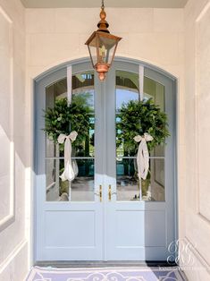 two wreaths are hanging on the front door