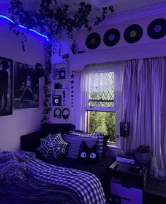 a bedroom decorated in purple and black with lots of decorations on the walls, bedding, and curtains