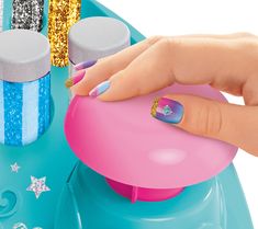 a woman's hand on top of a pink and blue table with glitters