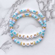 "Beach Bum bracelet set! Handmade with love using Czech glass beads, white and gold letter beads and stretch cord. Get creative! All my bracelets are meant to be mixed, matched & stacked!  SIZING: Measure your wrist around the widest point and add .25-.5 inches to get the most comfortable or desired fit. If you don't have a flexible tape measure, you can use a piece of string to wrap around your wrist and then measure the length of the string. (For example: my wrist size is 6\" and I will wear a Gold Beaded Bracelets With Letter Beads For Vacation, Positivity Bracelets, Aesthetic Beads, Selling Bracelets, Bracelets Layering, Crafts Beads, Preppy Bracelets, Bracelet Inspo, Bracelets Ideas