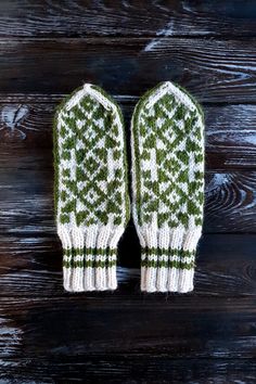 two green mittens sitting on top of a wooden table