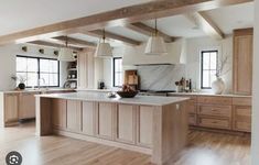 a large kitchen with wooden floors and white walls