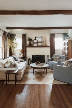 a living room filled with furniture and a fire place in the middle of a room