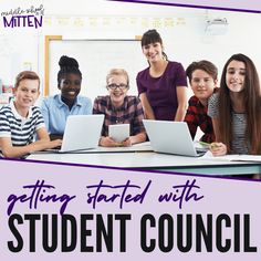 a group of young people sitting at a table with laptops in front of them