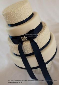 three tiered wedding cake with blue ribbon