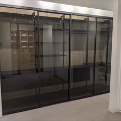 an empty room with glass doors and shelves