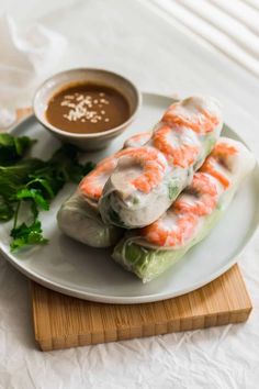 shrimp spring rolls on a plate with dipping sauce