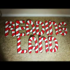 some candy canes are laying on the floor and reading land is spelled out