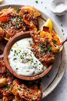 a white plate topped with fried potatoes covered in sour cream