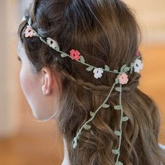 a woman with long hair wearing a flowered headpiece