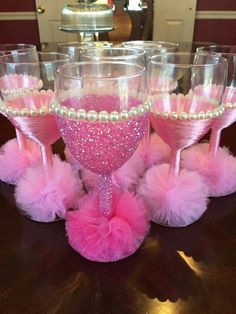 some wine glasses with pink and white decorations