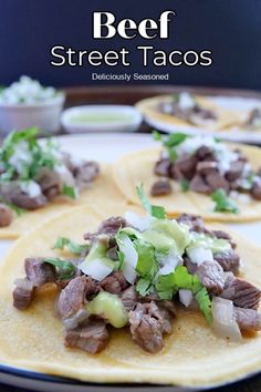 beef and avocado tacos on tortillas with sour cream, cilantro, and lime