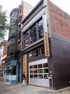 a tall brown building sitting on the side of a street next to a fire hydrant