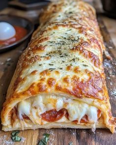 a close up of a piece of pizza on a wooden table with sauce and cheese