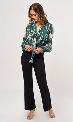 The Estelle neck tie blouse features a high neck collar that can be tied in any form or even left alone for that open tie look. The puff sleeves, floral fabric, and smocked waist add a touch of elegance to this style. Blouse Floral Tie front Puff sleeve Long sleeve Smocked waist Self: 100% Polyester Lining: 92% Polyester, 8% Spandex Length: 21" Chest: 19 1/2" Hand wash in cold water. Lay flat to dry. Low iron. Style #: G239T6868 Green Blouson Sleeve Blouse For Work, Green Blouse With Blouson Sleeves For Work, Elegant Green Top With Gathered Sleeves, Elegant Green Floral Print Blouse, Green Tie Neck Top For Fall, Chic Green Tie Neck Blouse, Chic Tie Neck Blouse With Gathered Sleeves, Fitted Floral Print Blouse With Tie Neck, Chic Blouse With Gathered Sleeves And Tie Neck