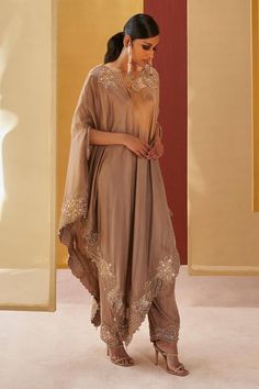 Beige asymmetric poncho kaftan with resham and jute embroidery. Paired with a salwar. Components: 2 Pattern: Embroidery Type Of Work: Resham, Jute, Sequins Neckline: Boat Neck Sleeve Type:  Three Quarter Sleeves Fabric: Silk Color: Beige Other Details:  Salwar: Resham embroidered hem Occasion: Sangeet - Aza Fashions Diwali Pattern, Salwar Women, Jute Embroidery, Priyanka Singh, Indian Dresses For Women, Pakistani Dresses Online, Indian Fashion Trends, Kaftan Designs, Embroidered Hem