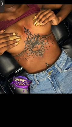 a woman's stomach with tattoos on it and her hands resting on the belly