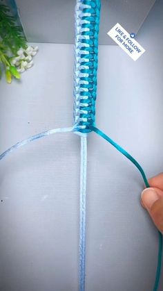 a person is holding a piece of blue string