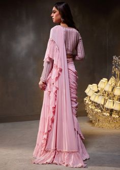 Our Elsa sari set reimagines traditional elegance through a modern lens, making it the perfect choice for celebrating special occasions. The set exudes sophistication with its ruffle sari, intricately embellished blouse, and meticulously hand-adorned belt. Elegant Pre-draped Saree With Sheer Dupatta For Reception, Elegant Georgette Pre-draped Saree With Zari Work, Elegant Fitted Pre-draped Saree With Mirror Work, Wedding Pre-draped Saree For Eid With Cape Sleeves, Elegant Pre-draped Saree With Zari Work, Elegant Pre-draped Saree With Dupatta For Festivals, Elegant Festive Pre-draped Saree With Dupatta, Elegant Fitted Pre-draped Saree For Navratri, Festive Elegant Blouse Piece In Traditional Drape