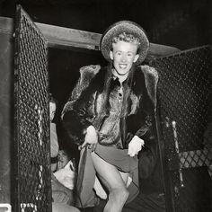 a black and white photo of a woman in a fur coat