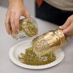 a person pouring gold glitter onto a paper plate