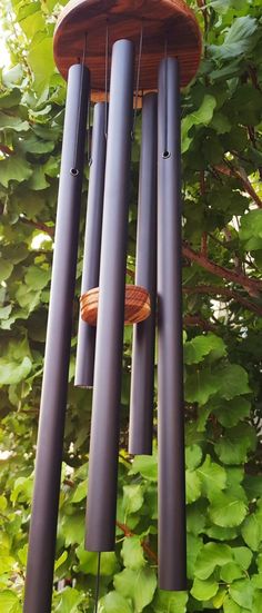 a wind chime hanging from the side of a tree with lots of green leaves