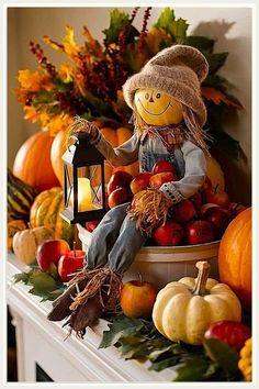 a scarecrow doll sitting on top of a mantle surrounded by pumpkins