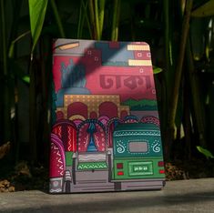 a colorful bag sitting on the ground next to some plants