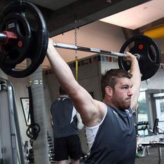 a man lifting a barbell in a gym