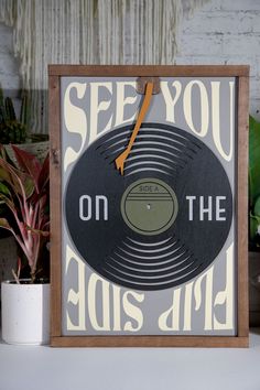 an old record with the words see you on the side next to a potted plant