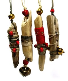 three pieces of driftwood with bells and beads hanging from it's sides on strings