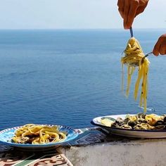 a person is eating some food by the ocean