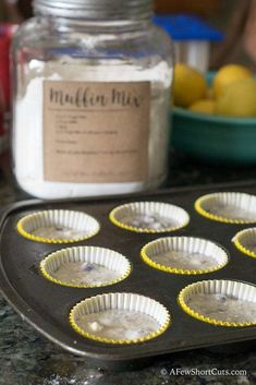 muffin tins filled with batter sitting on top of a counter next to a bowl of lemons