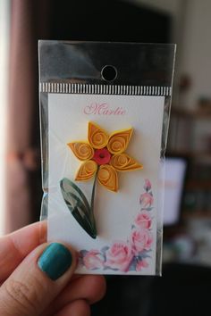 a person holding up a card with a flower on it