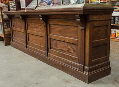 a large wooden counter sitting inside of a store next to shelves with magazines on it