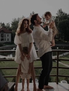 a man, woman and child standing on a balcony