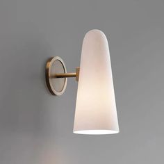 a wall light that is on the side of a gray wall with a white shade