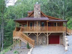 a log cabin with stairs leading up to the front door and second story deck area