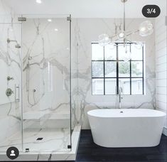 a white bath tub sitting next to a walk in shower