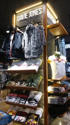 clothes and t - shirts are on display in a clothing store, with the name david jones above them