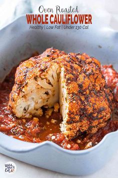 a cauliflower covered in marinara sauce with a piece cut out