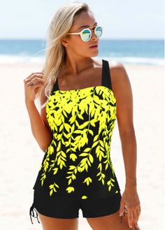 a woman standing on the beach wearing a yellow and black one piece swimsuit with leaves