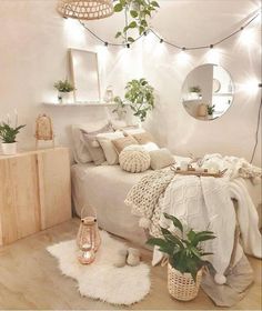 a bedroom with white walls and wooden flooring, plants in baskets on the bed