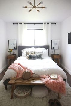 a bedroom with a white bed and pink fur rugs on the floor next to a window