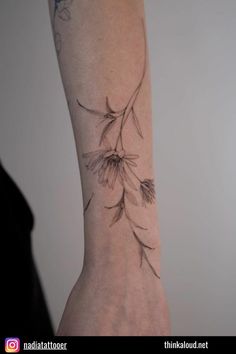 a woman's arm with a flower tattoo on it